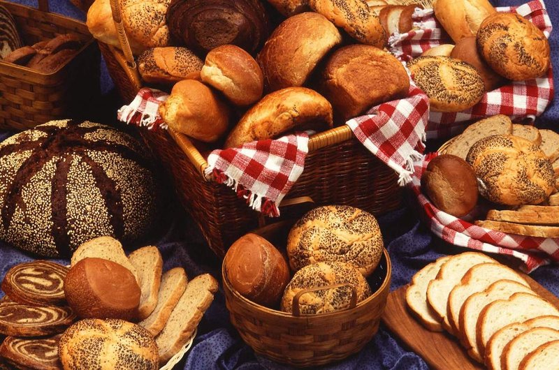 A selection of various breads elegantly arranged on a table, showcasing different shapes and textures